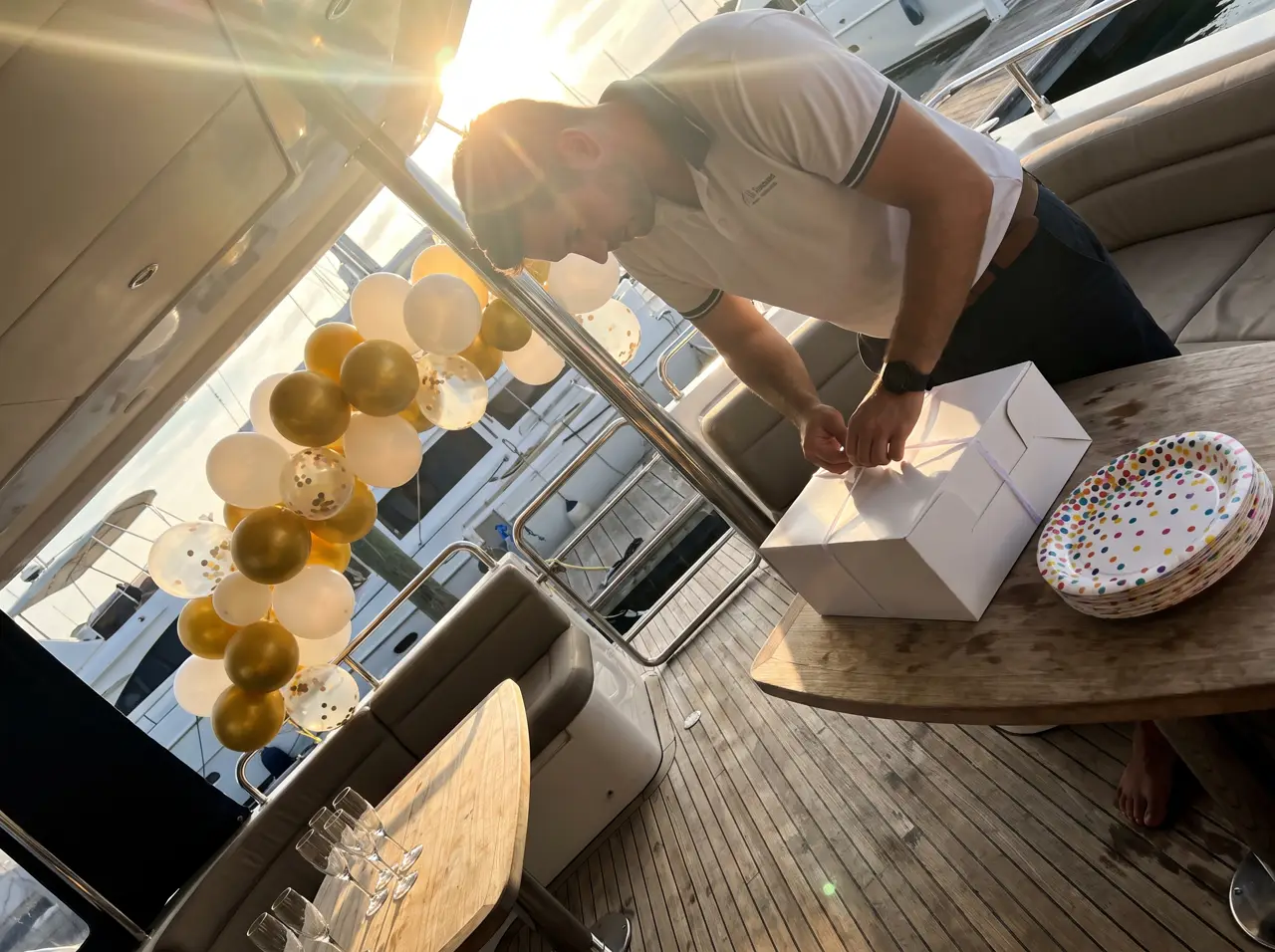 Yacht saloon decorated for a birthday with balloons and a cake on the table