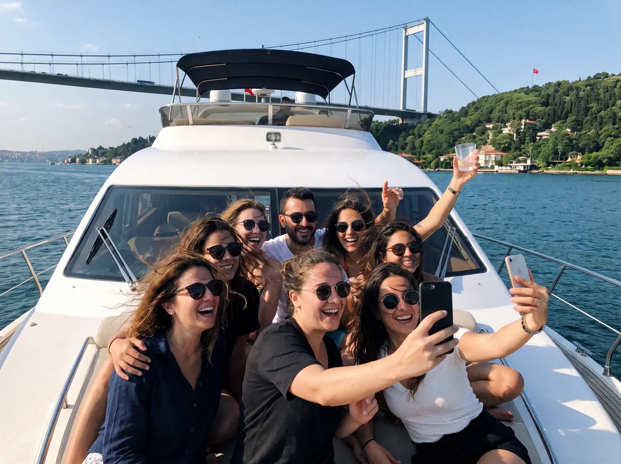 Group of friends laughing on the bow of a yacht on the Bosphorus