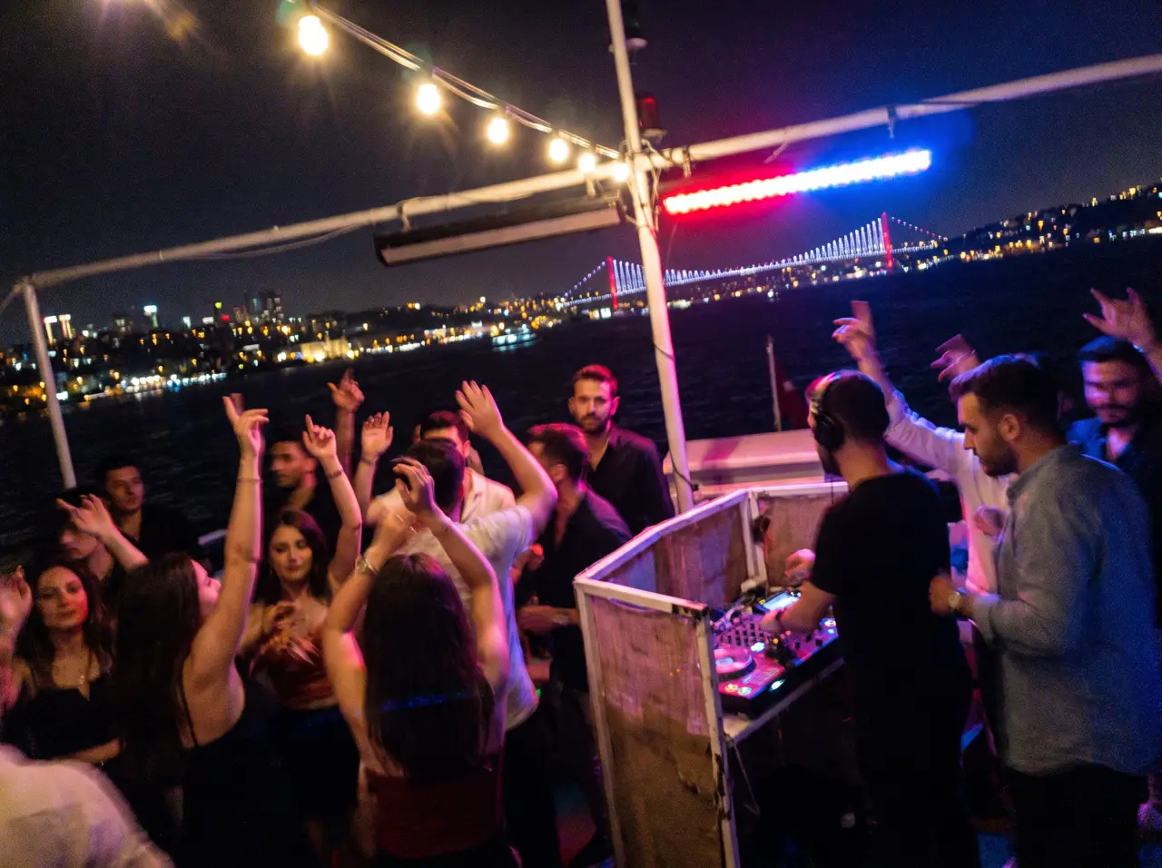Friends dancing on a yacht deck at night during a private party in Istanbul